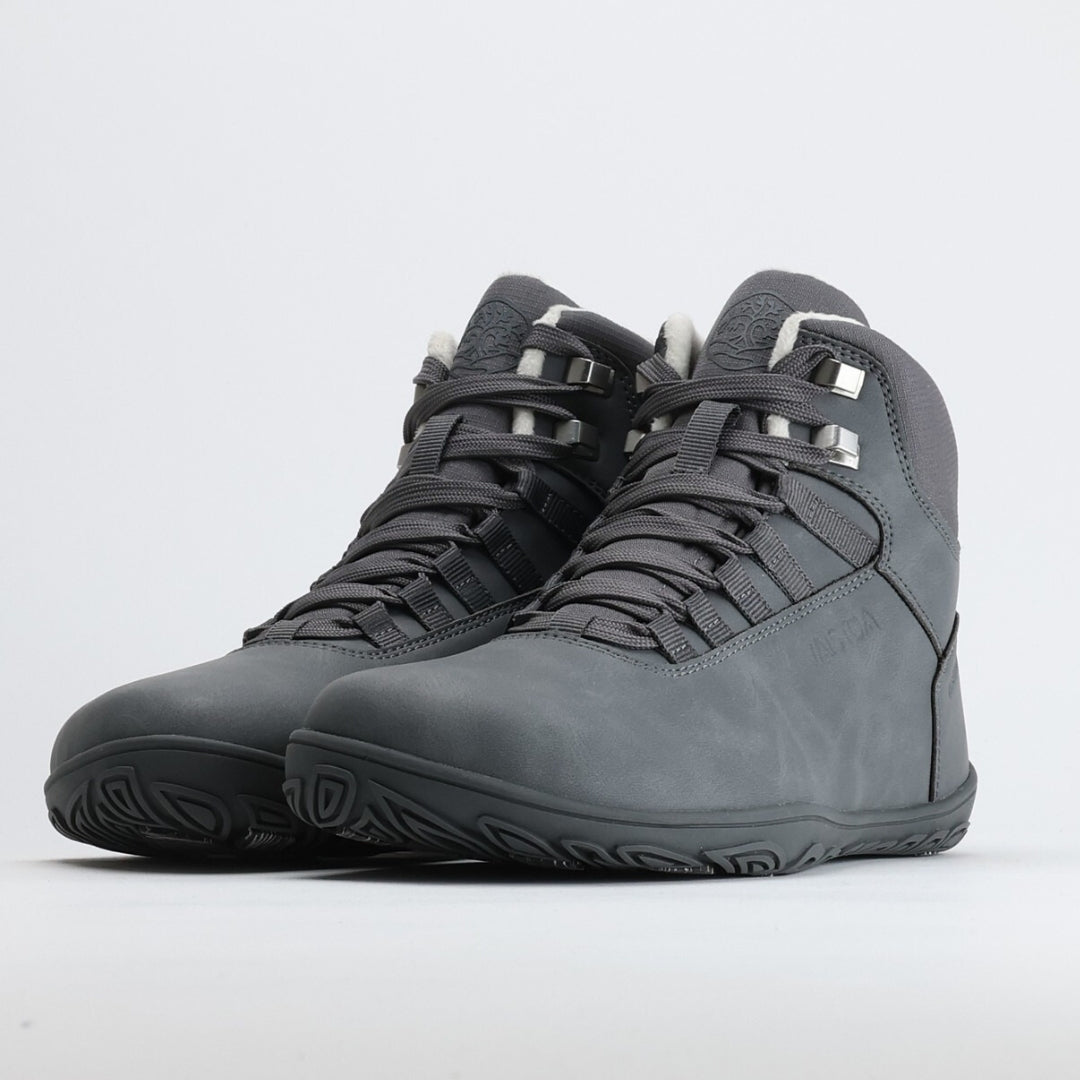 Pakkasharmaa Vaistoa Uoma Talvi 3 -kenkäpari kuvattuna etuviistosta, korostaen kengän matalaa profiilia ja leveää varvastilaa.