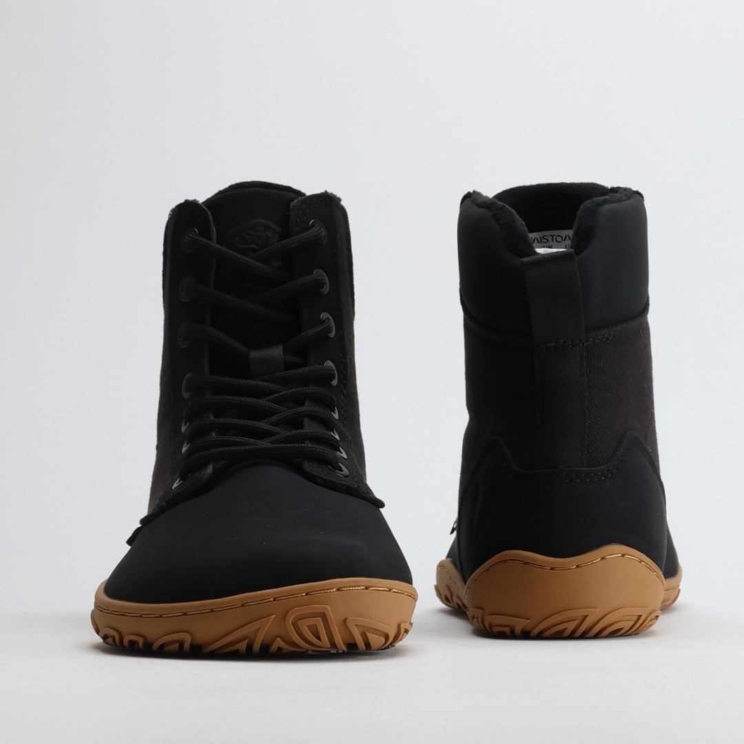 Musta Vaistoa Hurmos 2 -paljasjalkamaiharipari kuvattuna edestä ja takaa. Kuvassa näkyvät kengän korkea varsi, nauhoitus ja ruskea ohut pohja.