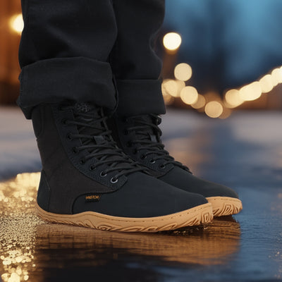 Musta Vaistoa Hurmos 2 -paljasjalkamaiharipari jalassa iltakuvassa. Henkilö seisoo märällä kadulla, ja heijastuvat katuvalot luovat lämpimän tunnelman.