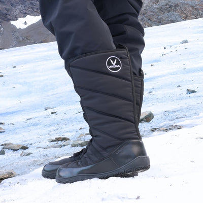 Vaistoa Hanki – korkeavartiset paljasjalkakengät talveen, väri musta. Käyttökuva: takaviistosta kuvattuna, henkilö seisoo lumisilla tuntureilla kirkkaassa talvipäivässä – kuva välittää luonnonrauhan ja liikkumisen vapauden.